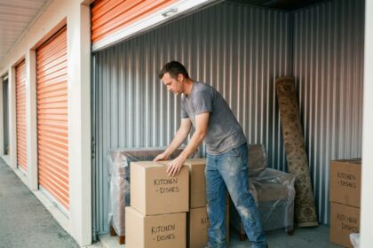 Homme rangeant des cartons dans un box de stockage pendant des travaux de rénovation